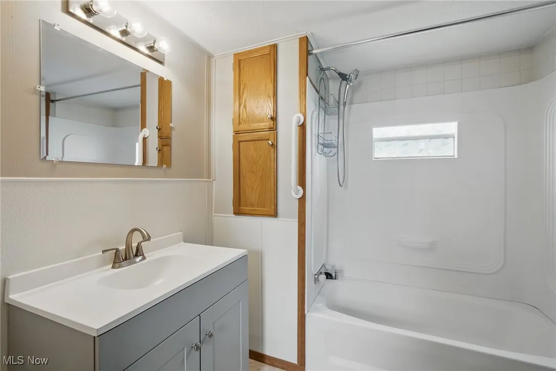 Full bath featuring vanity and shower / washtub combination