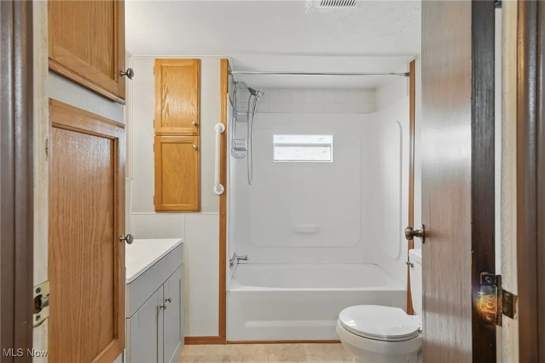 Bathroom with vanity, toilet, and bathing tub / shower combination