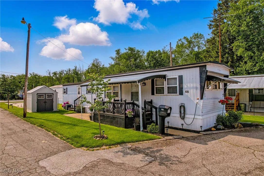 Manufactured / mobile home with a front yard and covered porch