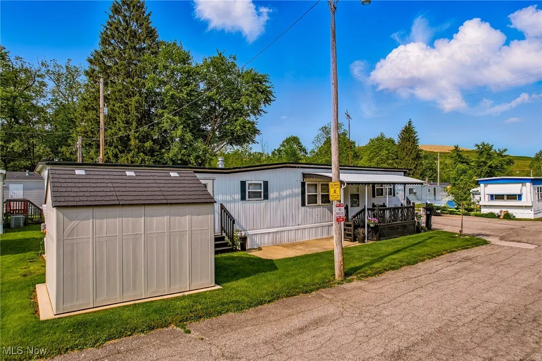 Manufactured / mobile home featuring a front lawn, a porch, and cooling unit
