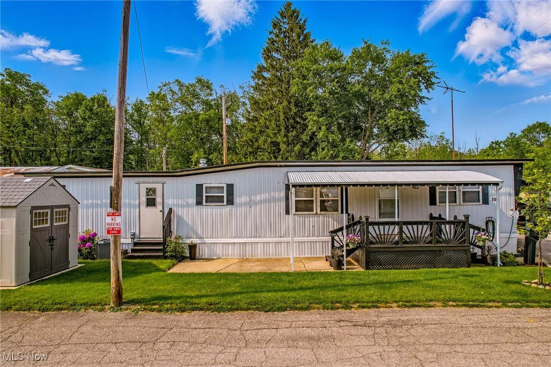 Manufactured / mobile home featuring a front lawn and covered porch