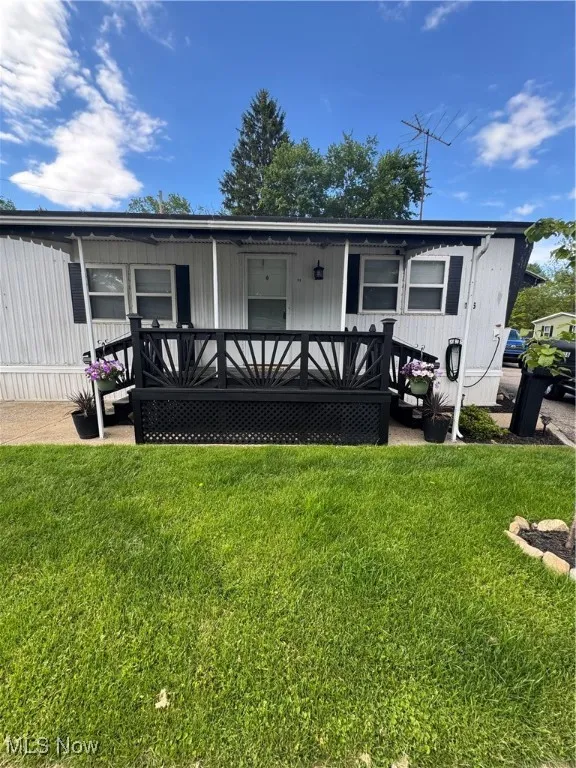 View of front of home with a front lawn and a deck