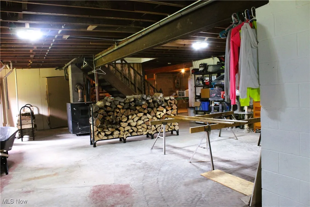 Basement featuring stairway and concrete block wall
