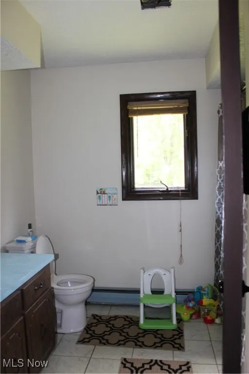Full bath featuring toilet, vanity, and baseboard heating