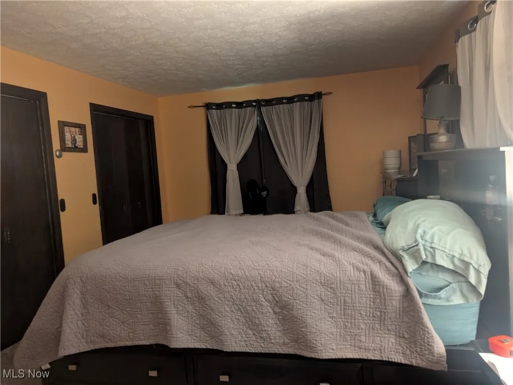 Bedroom featuring a textured ceiling and a closet