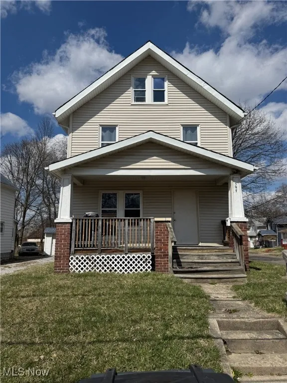 American foursquare style home with covered porch and a front yard