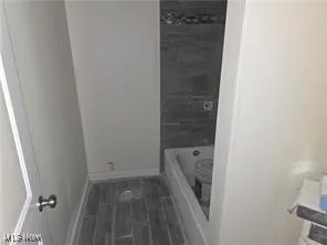 Bathroom featuring a bath and baseboards