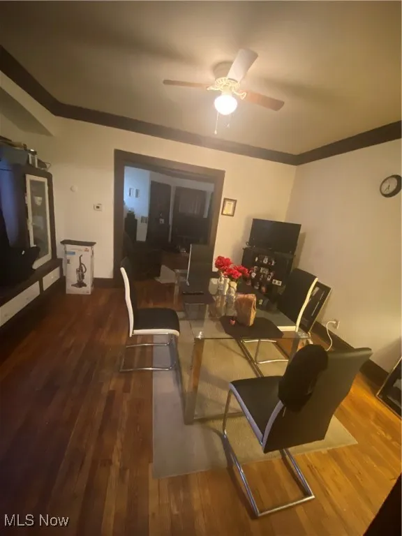 Living area with a ceiling fan, wood finished floors, and crown molding