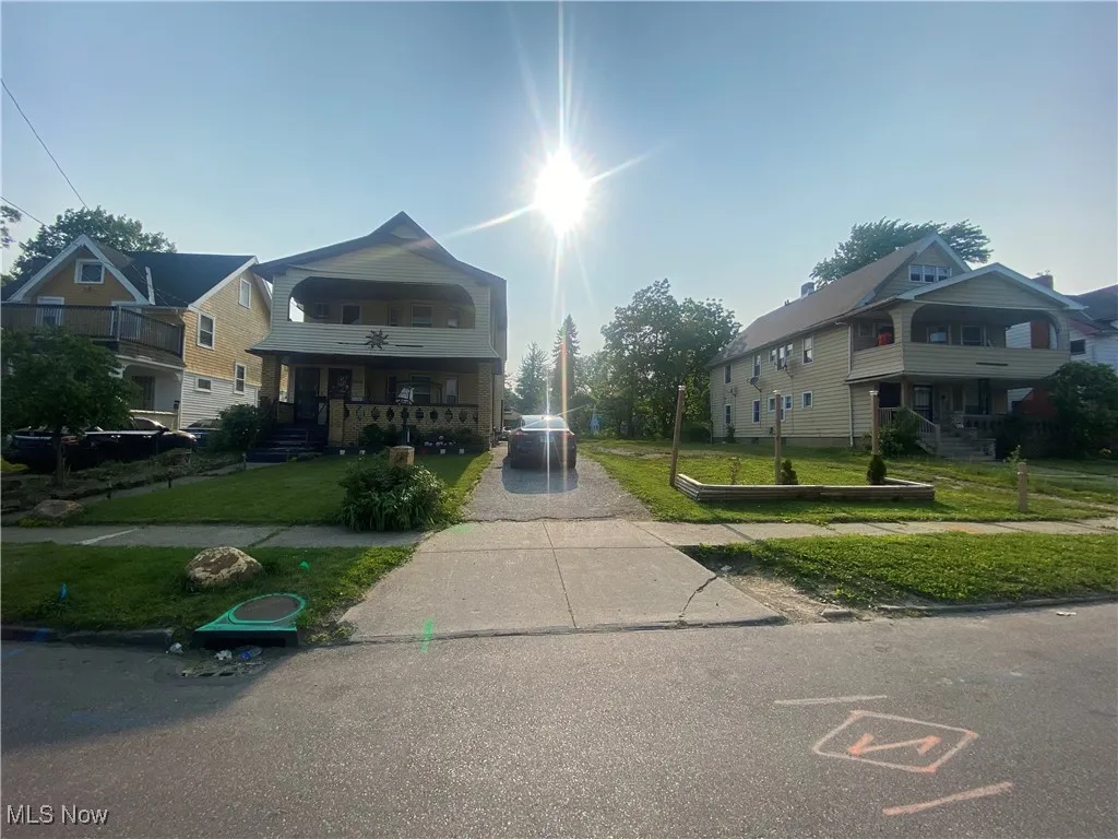 View of front of property with a front yard, a porch, driveway, and a ceiling fan