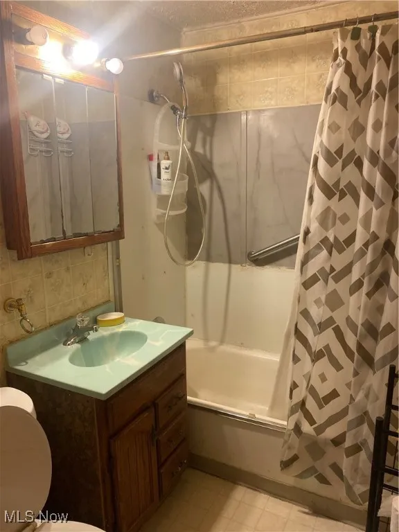 Full bathroom featuring shower / tub combo and vanity