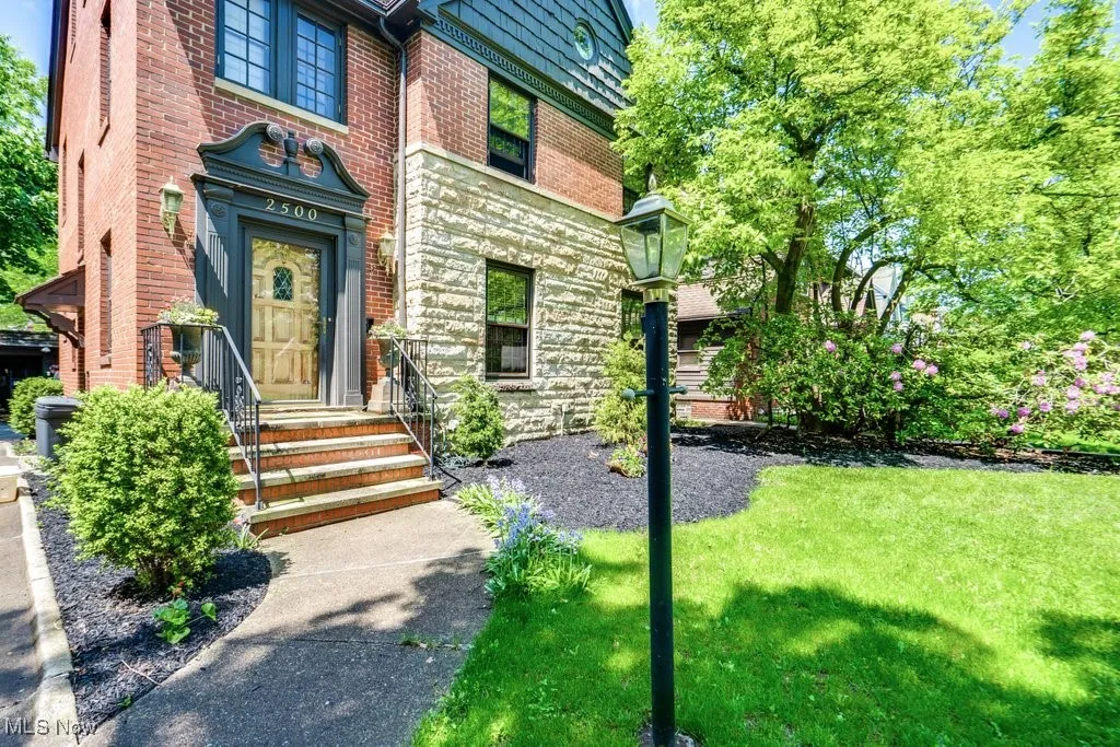 Doorway to property with brick siding and a yard