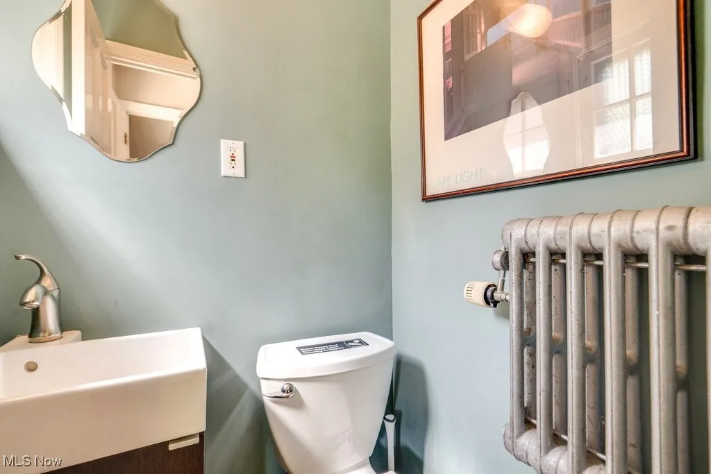 Bathroom featuring radiator, toilet, and a sink