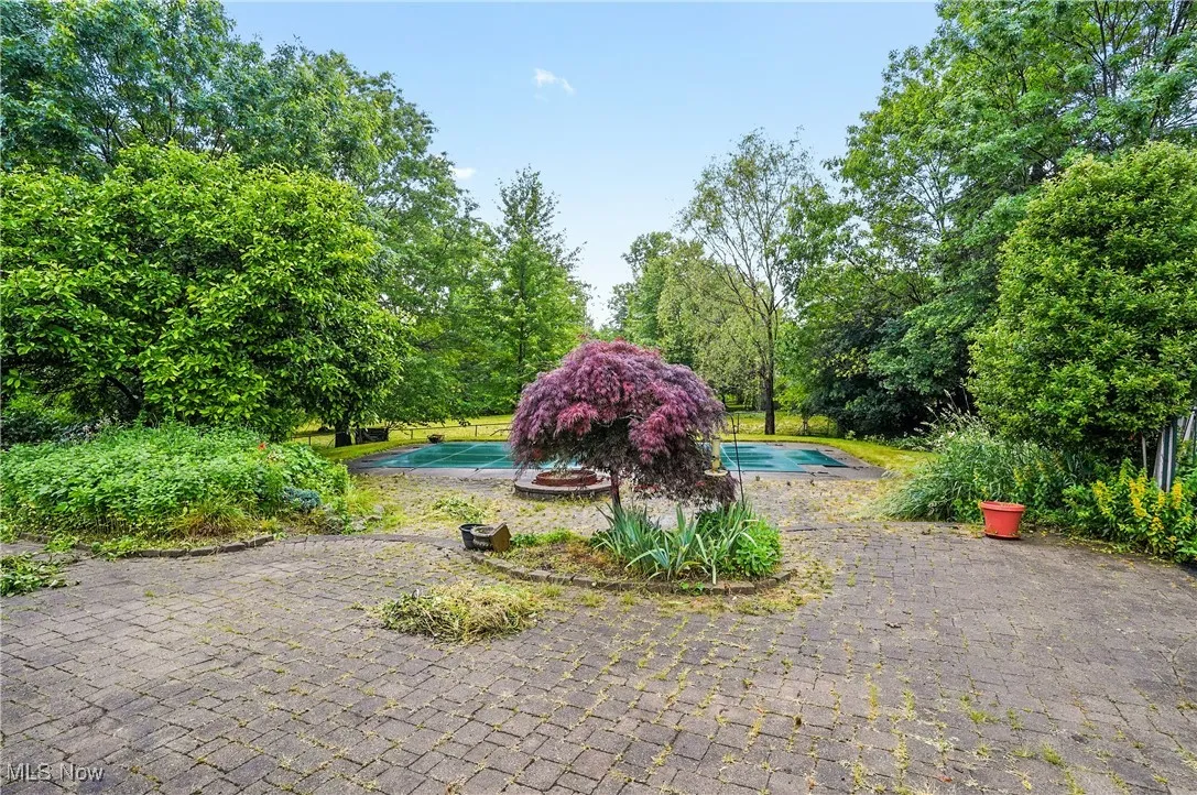 View of yard featuring an outdoor pool and view of scattered trees