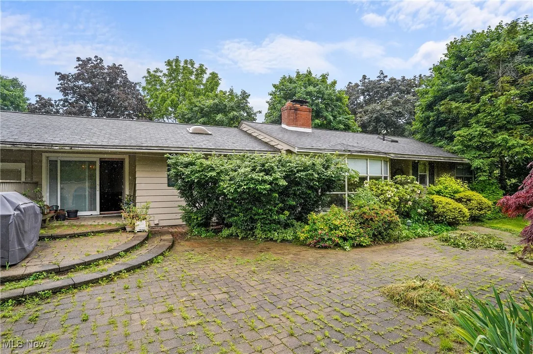 View of front of house featuring a chimney and a patio