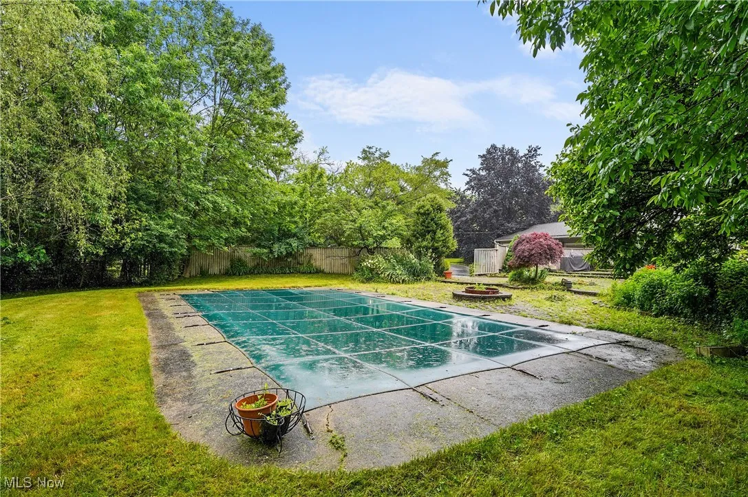 View of pool with an outdoor fire pit and a patio