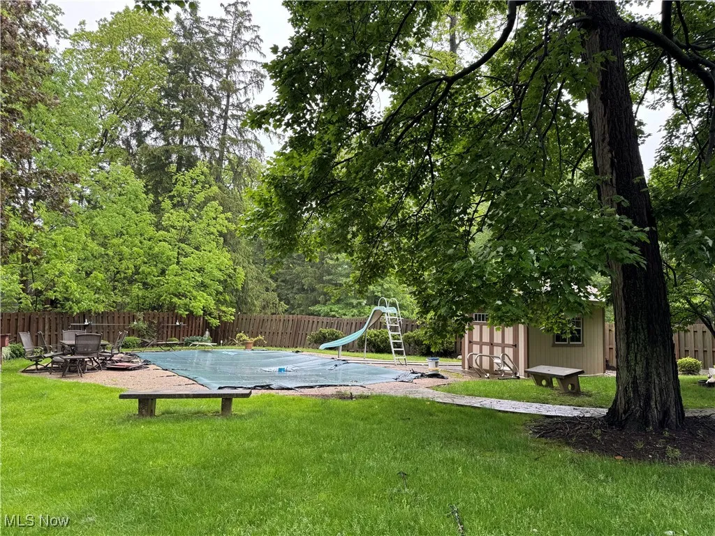 View fenced backyard and and pool house