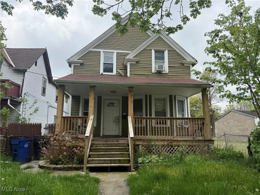 View of front of home with a porch and fence