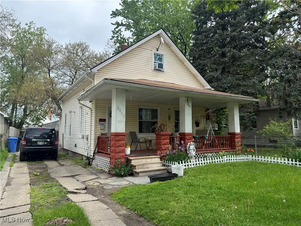 View of front facade featuring covered porch and a chimney