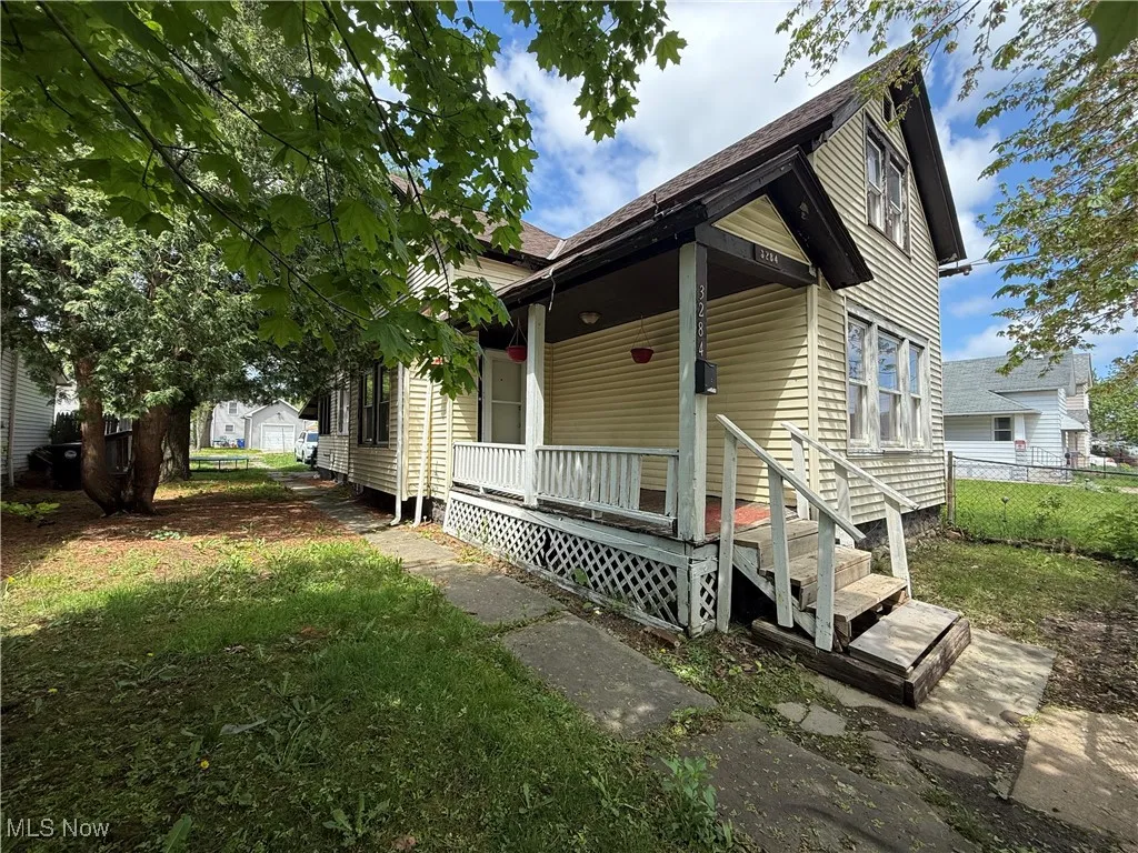 View of front facade with a porch and fence