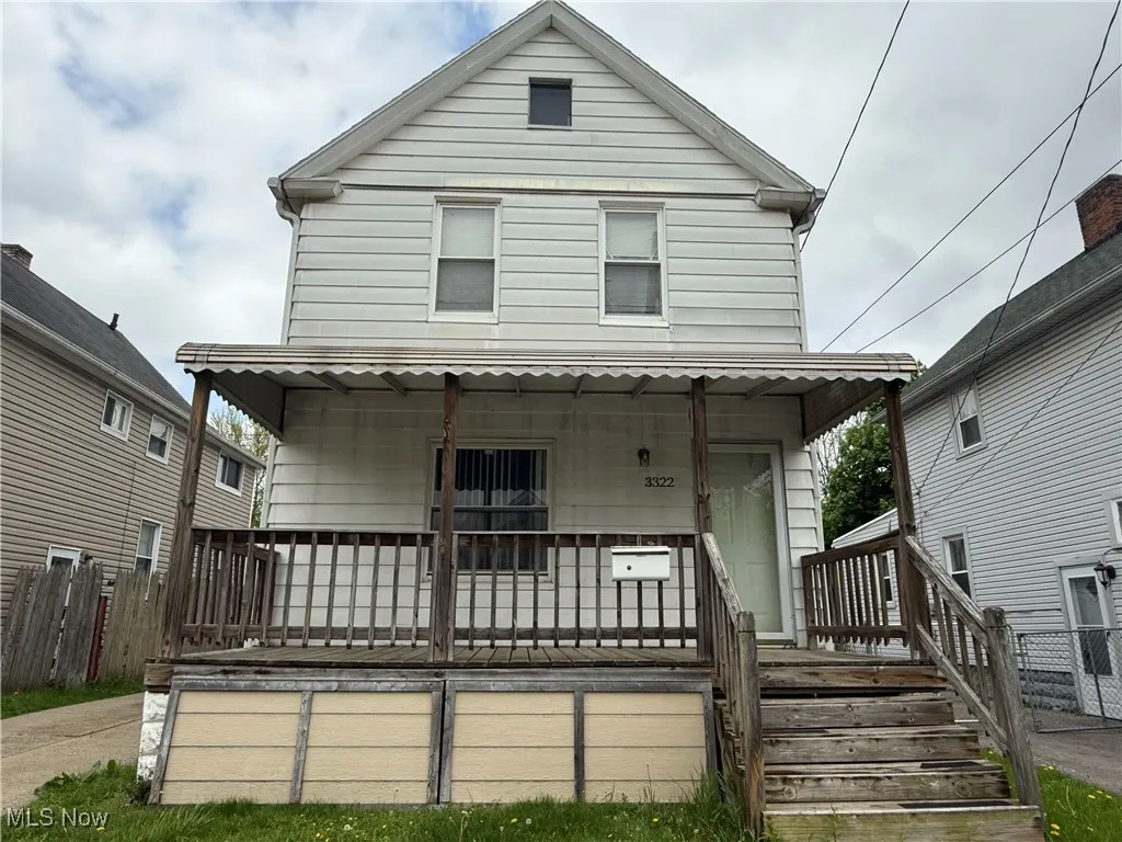 Front view of property with covered porch and fence