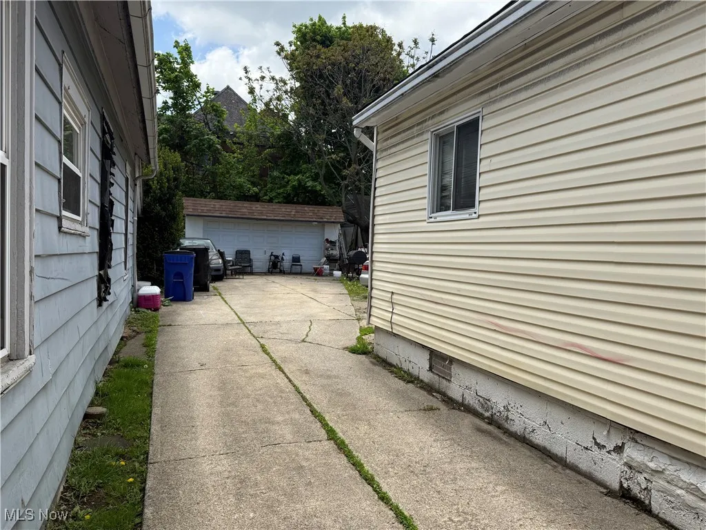 View of side of home with a garage, crawl space, and an outbuilding