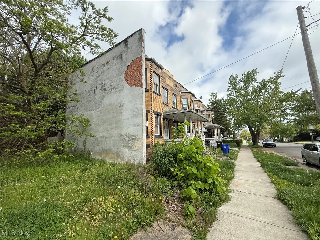 View of property exterior with a porch and brick siding