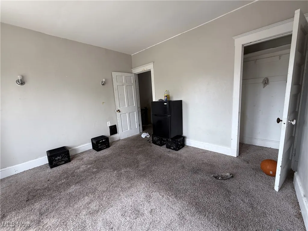Unfurnished bedroom featuring carpet floors, baseboards, and a closet