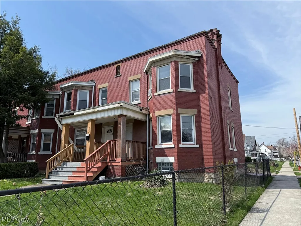 Multi unit property featuring brick siding and a porch