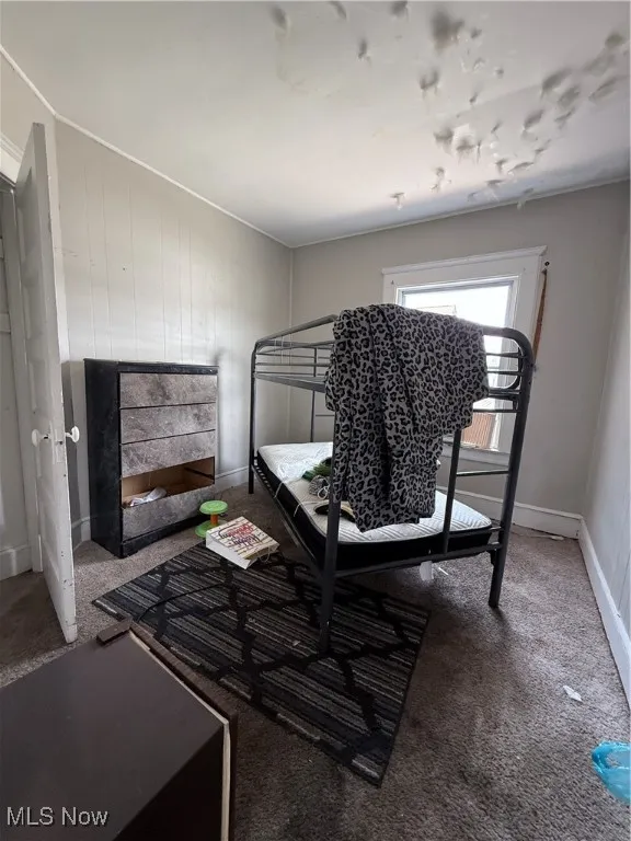 Bedroom featuring carpet flooring and baseboards