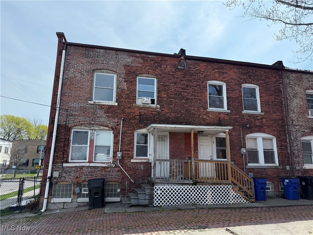 Townhome / multi-family property featuring brick siding and fence