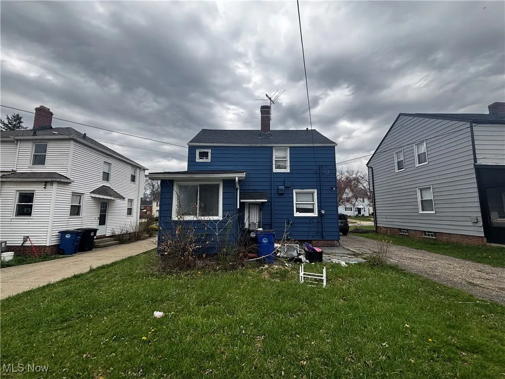 Rear view of house featuring a yard and a chimney