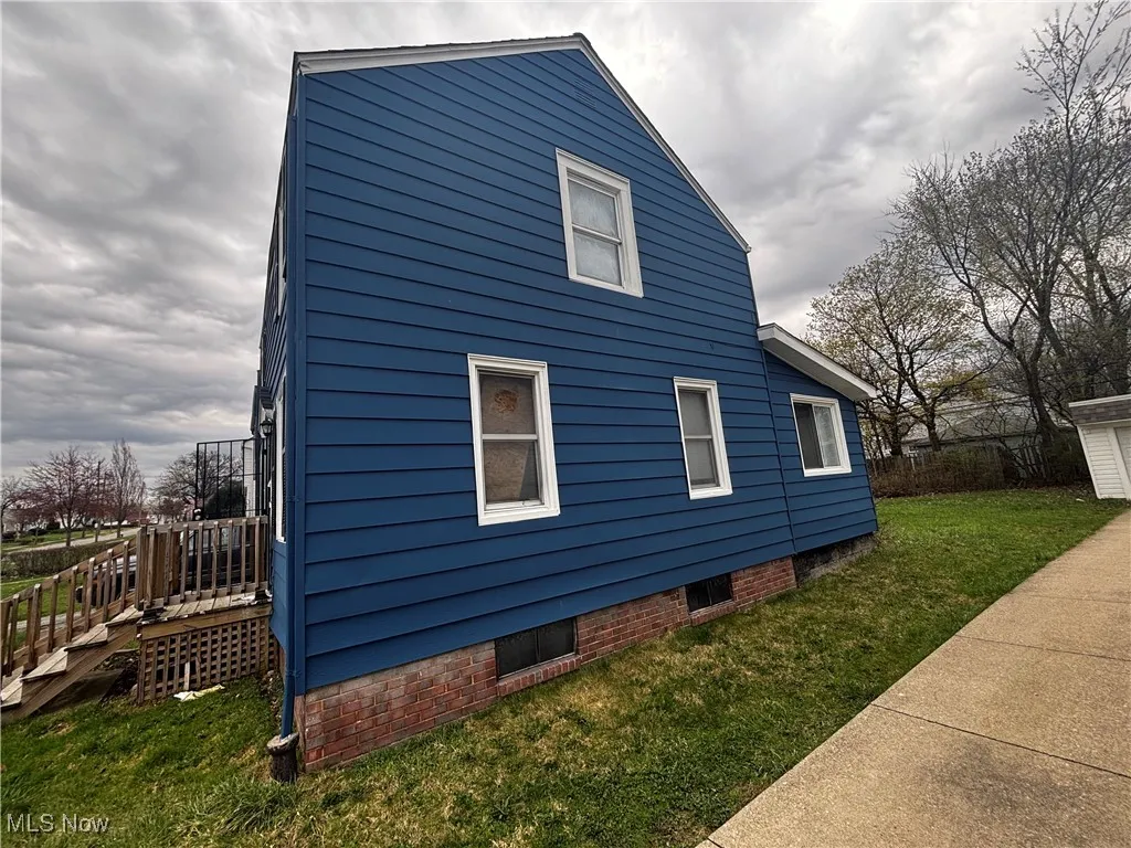 View of side of home featuring a lawn