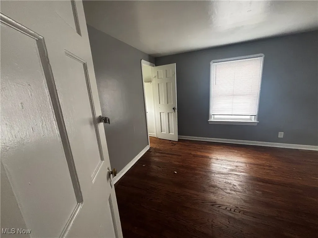 Unfurnished room with wood finished floors and baseboards