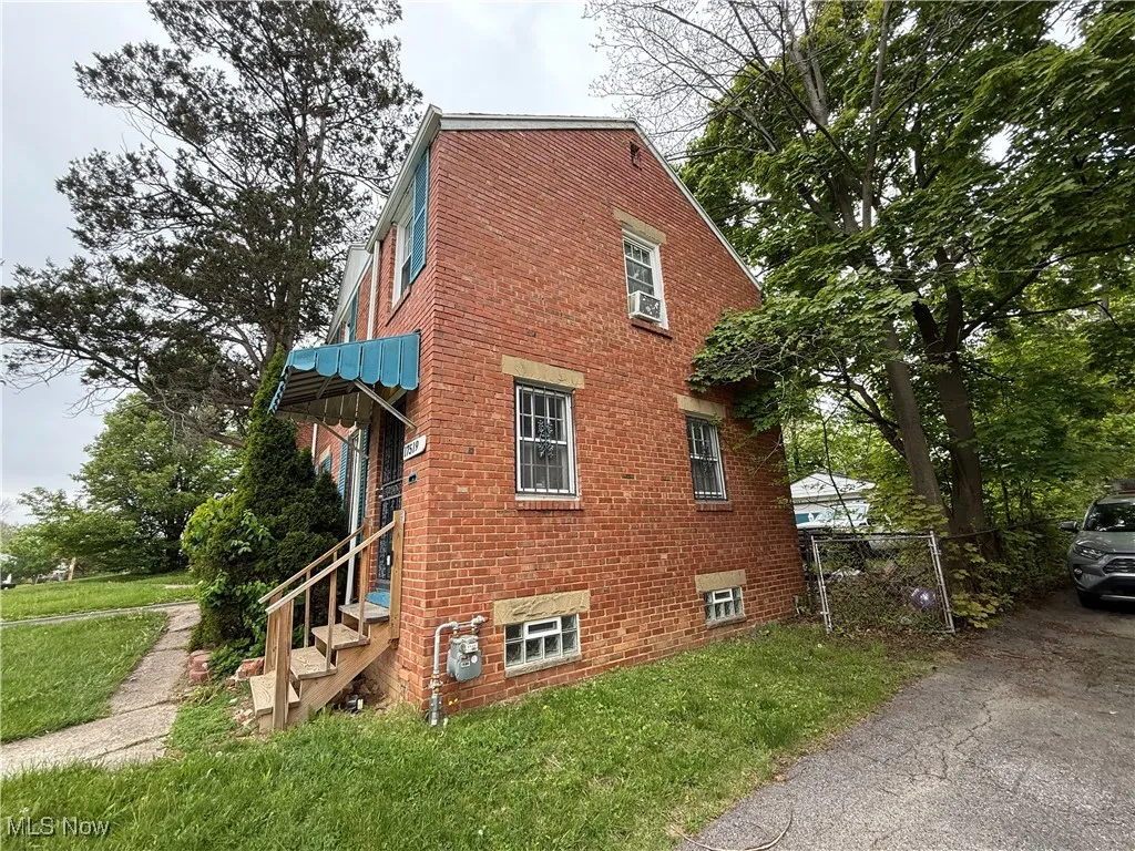 View of side of home with brick siding and cooling unit