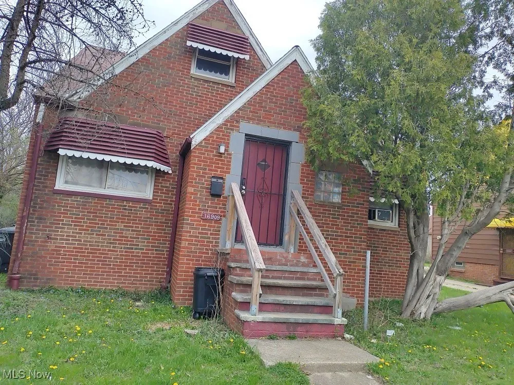 Tudor-style house with brick siding and a front yard