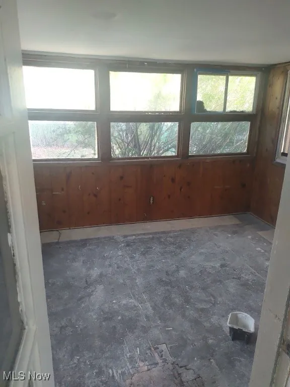 Spare room featuring wood walls