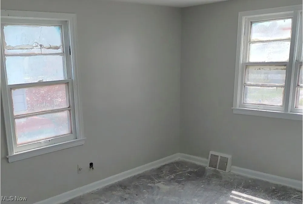 Spare room featuring baseboards and plenty of natural light
