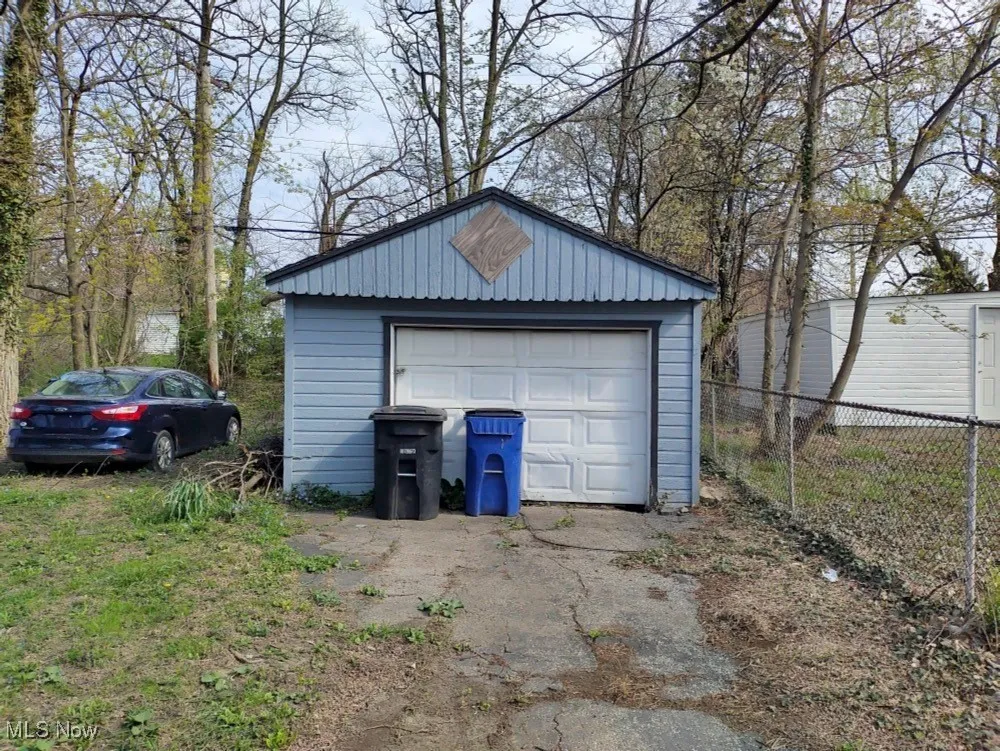 Detached garage with fence and asphalt driveway