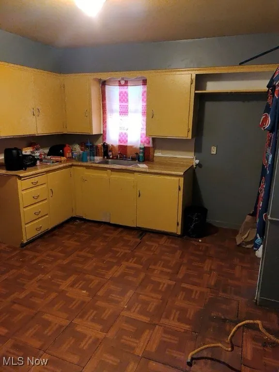 Kitchen with light countertops, white cabinets, and a sink