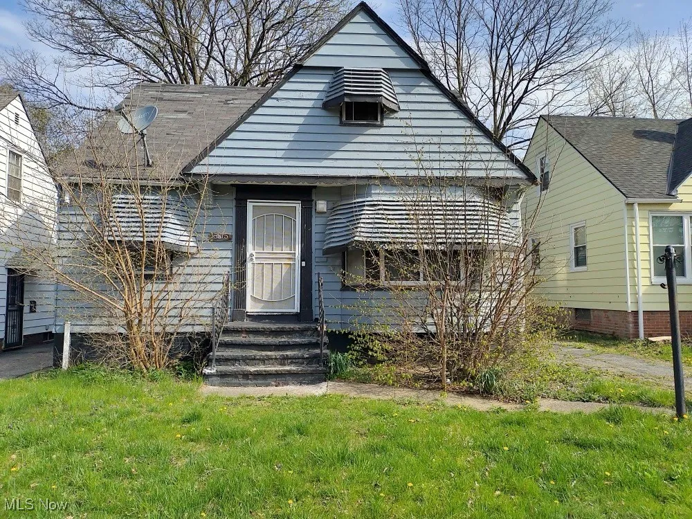 View of front of property with entry steps and a front lawn