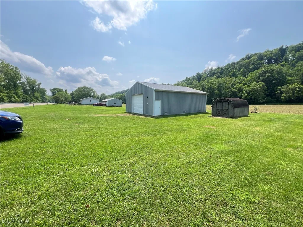 View of grassy yard with a garage and a storage unit