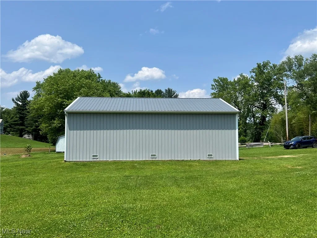 View of pole building with a lawn