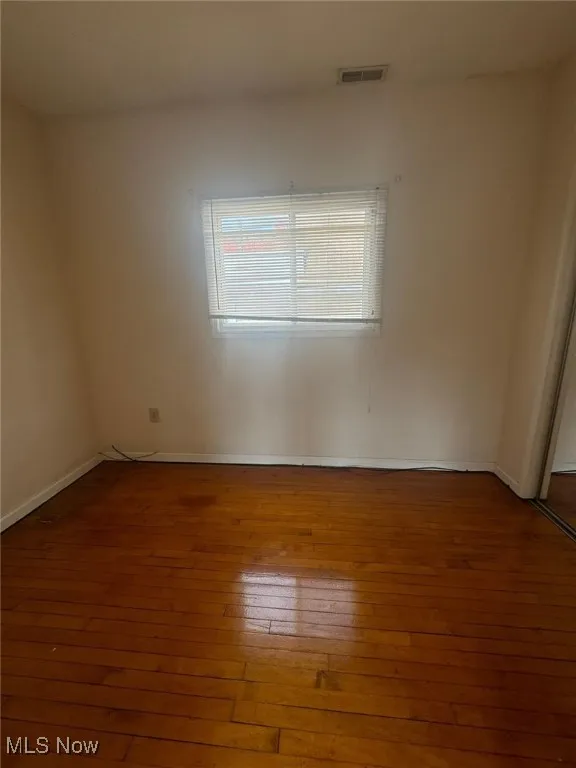 Empty room with hardwood / wood-style flooring and baseboards