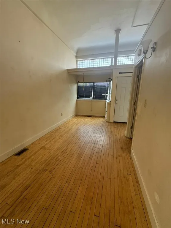 Unfurnished room with hardwood / wood-style floors and baseboards