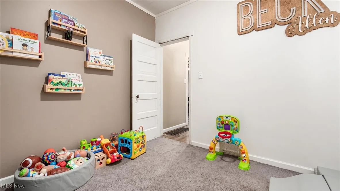 Recreation room featuring ornamental molding, carpet floors, and baseboards