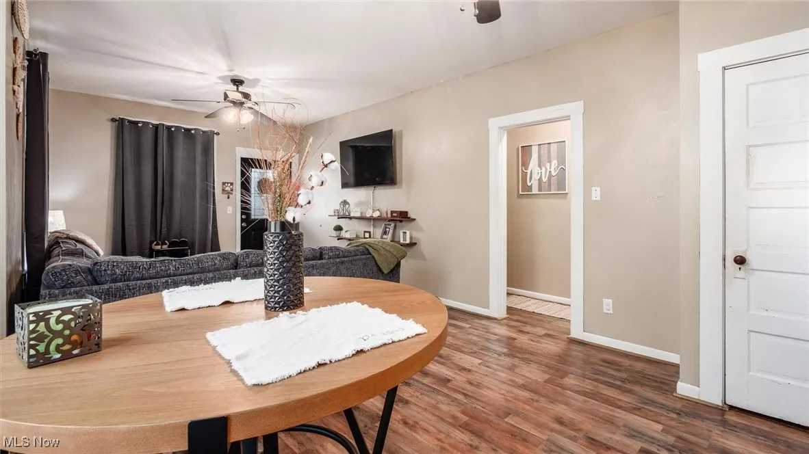 Dining space featuring a ceiling fan, wood finished floors, and baseboards