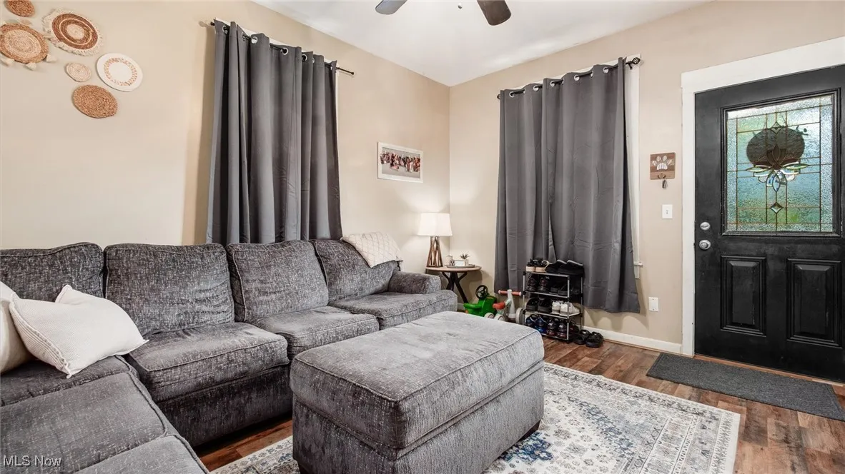 Living area featuring wood finished floors, ceiling fan, and baseboards