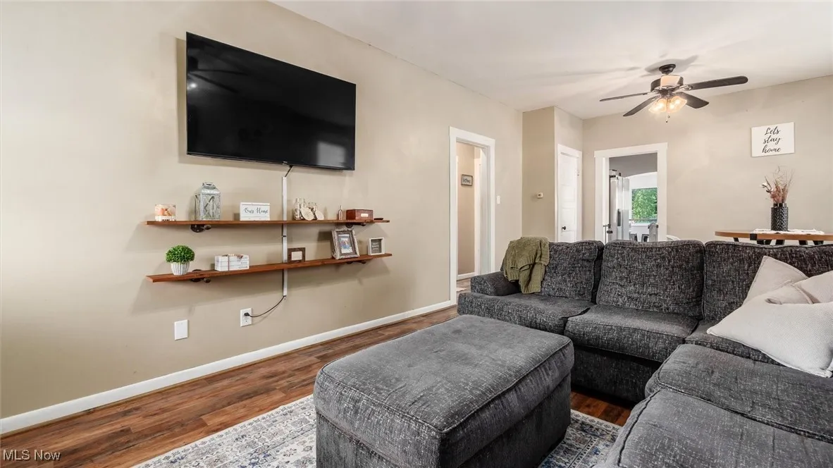 Living room featuring wood finished floors, baseboards, and ceiling fan