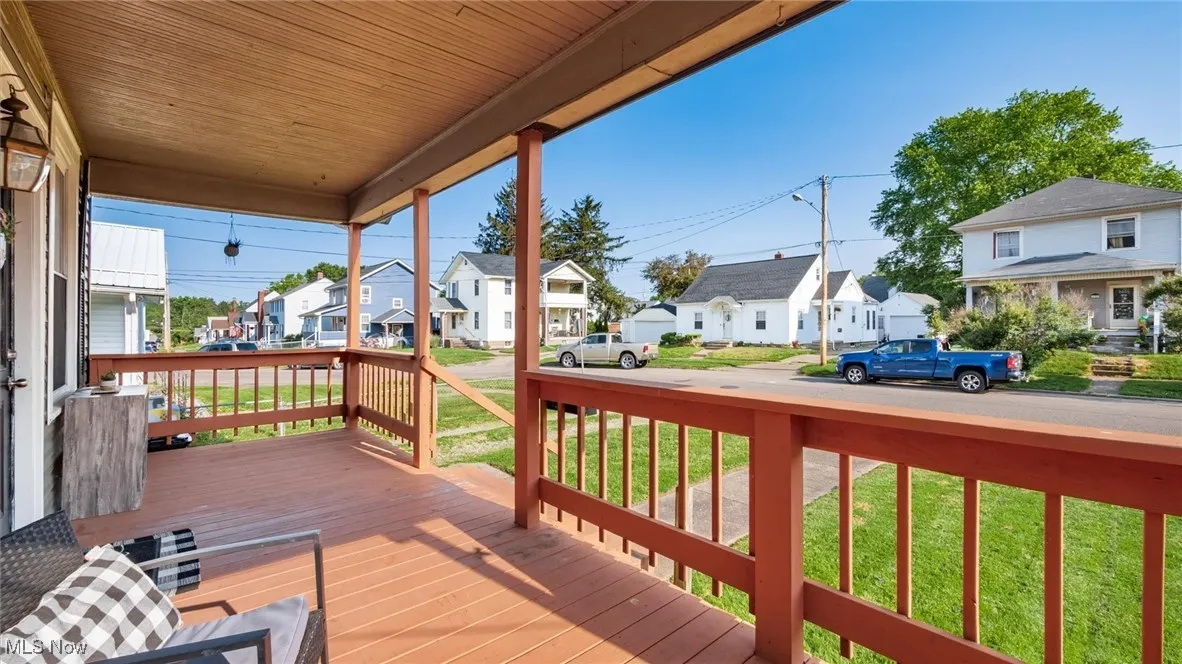 Wooden porch featuring a residential view and a lawn