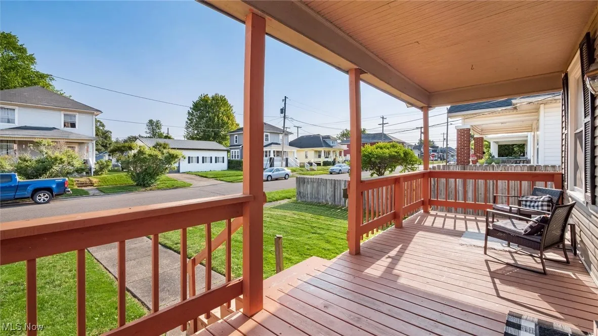 Wooden terrace featuring a residential view and a yard